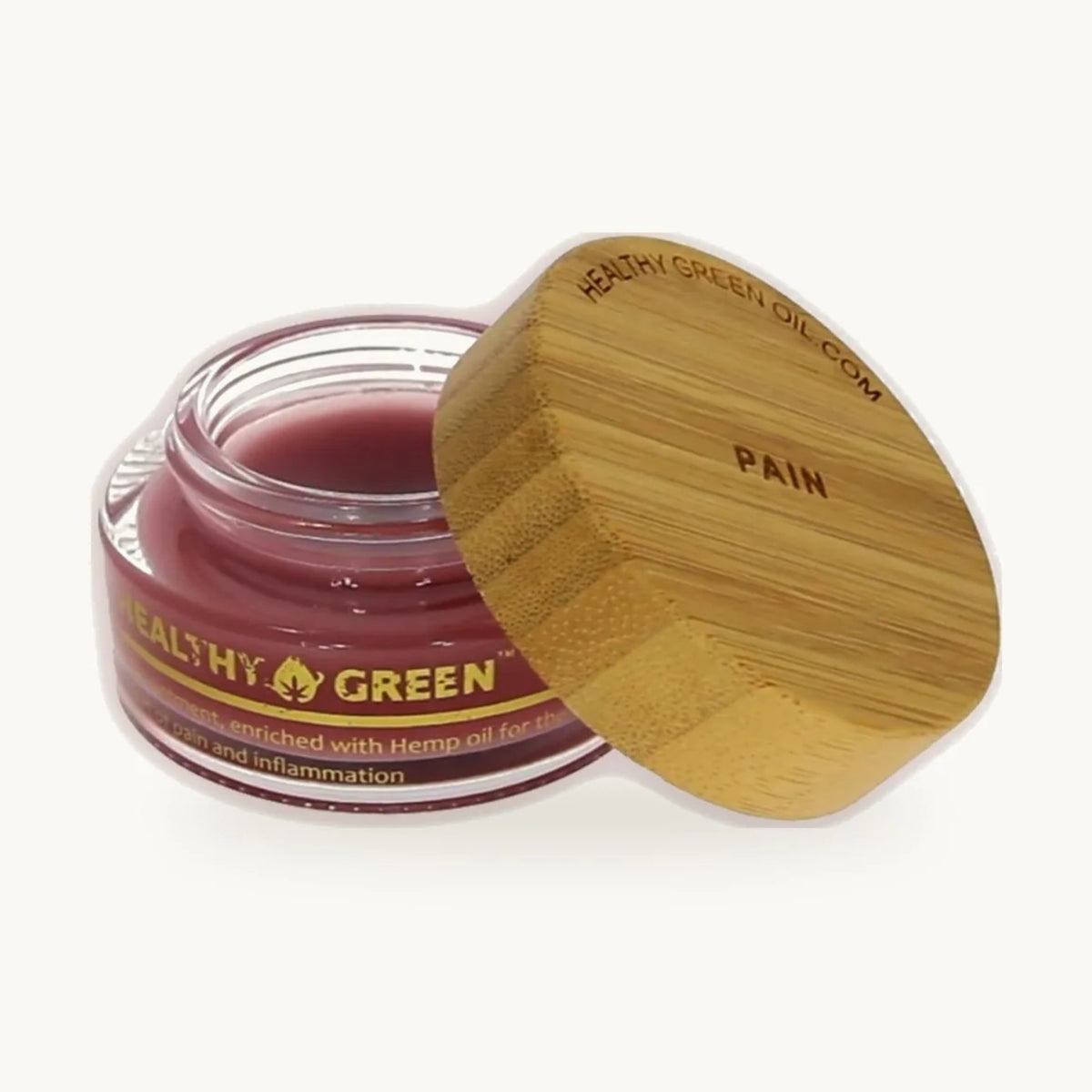 Healthy Green Botanical Balm — Ease, open glass jar of deep red balm with its engraved bamboo lid, on a soft cream background